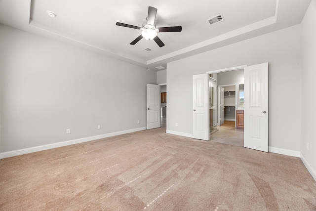 18738 Fox Kestrel Trl, Cypress, TX 77429 - unfurnished bedroom with a tray ceiling, light carpet, baseboards, and a spacious closet