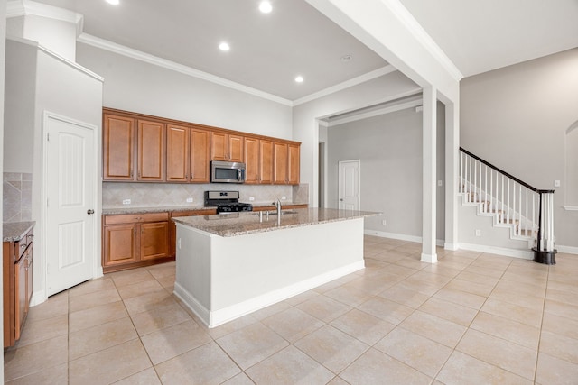 18738 Fox Kestrel Trl, Cypress, TX 77429 - kitchen with stainless steel microwave, light tile patterned floors, a sink, brown cabinets, and gas stove