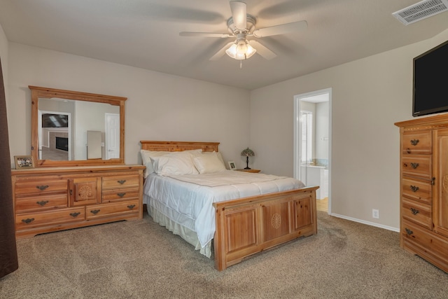4609 Woodspring Acres Ct, Kingwood, TX 77345 - bedroom with light carpet, baseboards, connected bathroom, and ceiling fan