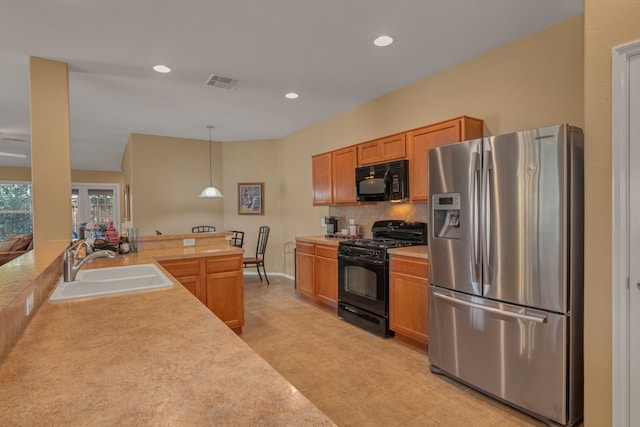 4609 Woodspring Acres Ct, Kingwood, TX 77345 - kitchen featuring black appliances, a sink, light countertops, hanging light fixtures, and backsplash