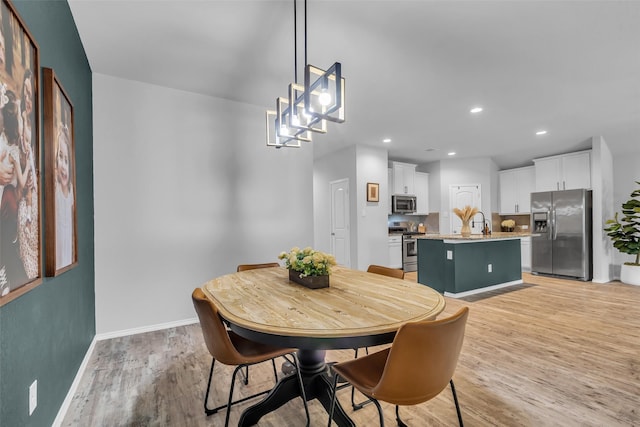 2322 Strong Horse Dr, Conroe, TX 77301 - dining room with light wood-style floors, baseboards, recessed lighting, and a chandelier