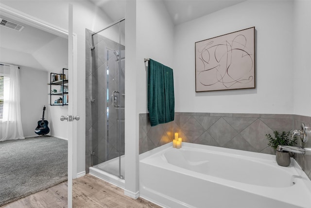 2322 Strong Horse Dr, Conroe, TX 77301 - bathroom with a garden tub, a shower stall, wood finished floors, and baseboards