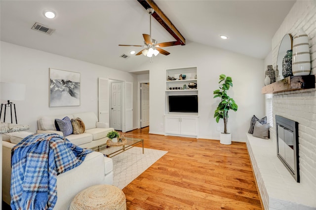 12427 Attlee Dr, Houston, TX 77077 - living area featuring light wood-style floors, a ceiling fan, a brick fireplace, built in shelves, and recessed lighting