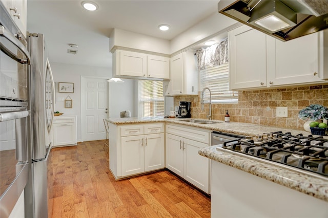 12427 Attlee Dr, Houston, TX 77077 - kitchen with a sink, custom range hood, a peninsula, white cabinetry, and light wood finished floors