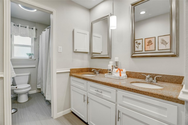 12427 Attlee Dr, Houston, TX 77077 - bathroom with toilet, double vanity, baseboards, and a shower with shower curtain
