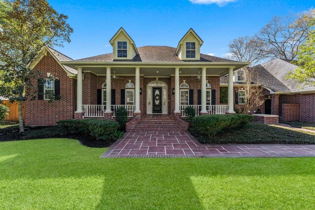 31026 Johlke Rd, Magnolia, TX 77355 - view of front of house with a front yard, brick siding, a porch, and roof with shingles