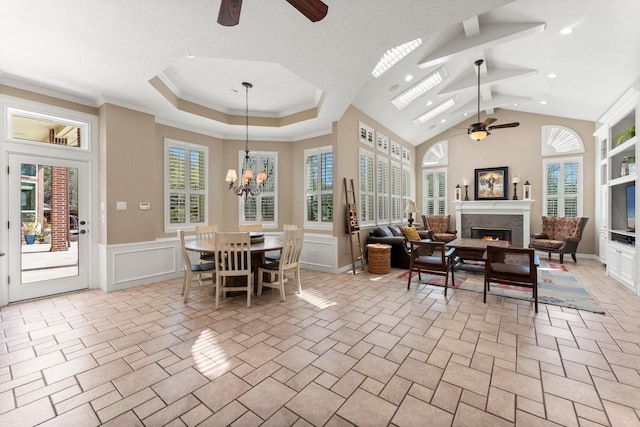 31026 Johlke Rd, Magnolia, TX 77355 - dining room with a ceiling fan, a warm lit fireplace, a wainscoted wall, a decorative wall, and recessed lighting