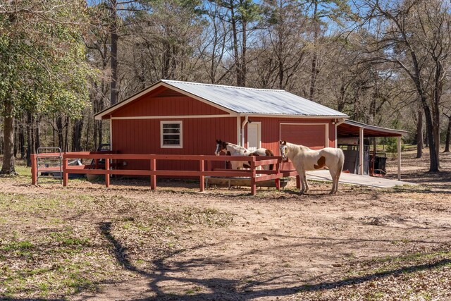 31026 Johlke Rd, Magnolia, TX 77355 - view of front facade with metal roof, a detached garage, an outbuilding, and driveway