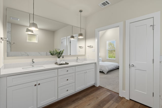 5626 Bertellis Ln, Houston, TX 77091 - bathroom featuring double vanity, wood finished floors, and connected bathroom