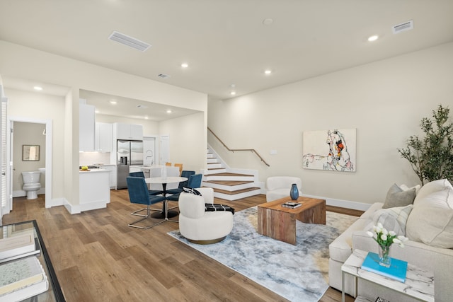 5626 Bertellis Ln, Houston, TX 77091 - living area with stairs, light wood-style floors, recessed lighting, and baseboards