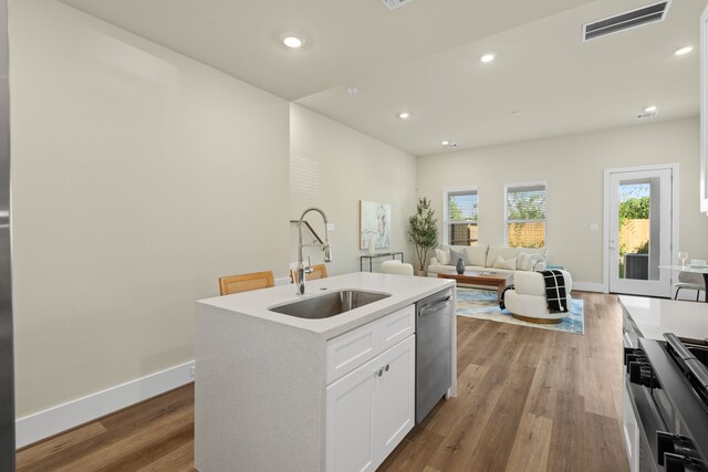 5626 Bertellis Ln, Houston, TX 77091 - kitchen featuring a sink, dishwasher, wood finished floors, white cabinetry, and baseboards