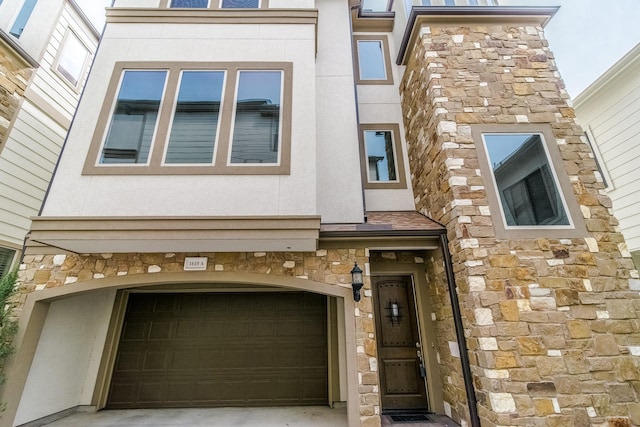 1610 Knox St Unit A, Houston, TX 77007 - townhome / multi-family property with stone siding, an attached garage, stucco siding, and driveway