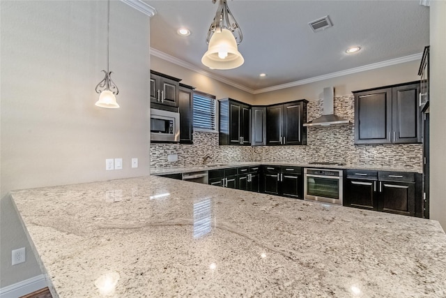 1610 Knox St Unit A, Houston, TX 77007 - kitchen featuring appliances with stainless steel finishes, wall chimney range hood, light stone countertops, backsplash, and decorative light fixtures