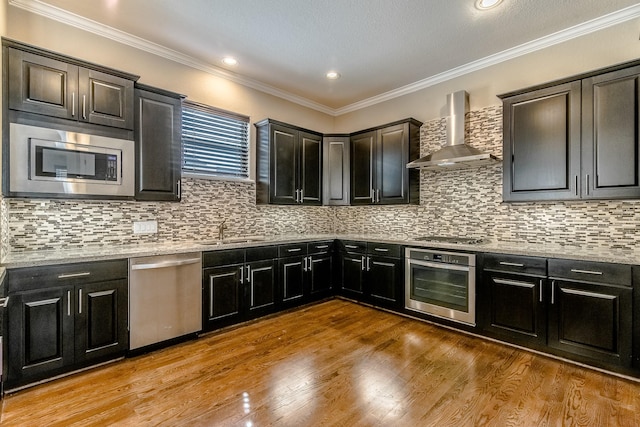 1610 Knox St Unit A, Houston, TX 77007 - kitchen with stainless steel appliances, wall chimney exhaust hood, a sink, tasteful backsplash, and wood finished floors