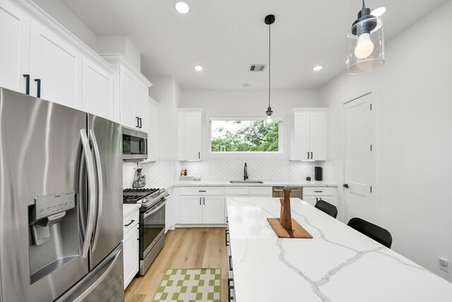 3022 Live Oak St, Houston, TX 77004 - kitchen with appliances with stainless steel finishes, a sink, tasteful backsplash, white cabinets, and recessed lighting