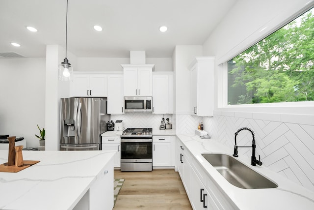 3022 Live Oak St, Houston, TX 77004 - kitchen featuring appliances with stainless steel finishes, a sink, backsplash, white cabinetry, and recessed lighting