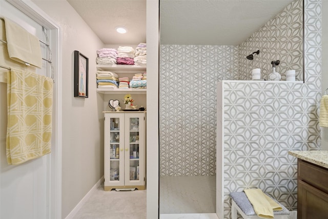 999 Arbor Gln, Conroe, TX 77303 - full bathroom featuring walk in shower, vanity, a textured ceiling, and baseboards