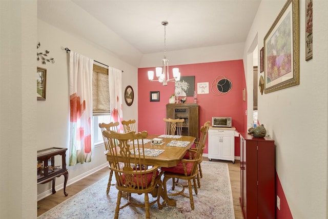 999 Arbor Gln, Conroe, TX 77303 - dining space with light wood finished floors, a chandelier, and baseboards