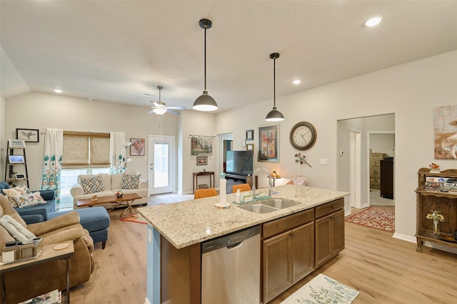 999 Arbor Gln, Conroe, TX 77303 - kitchen featuring stainless steel dishwasher, a sink, open floor plan, light wood-type flooring, and a center island with sink