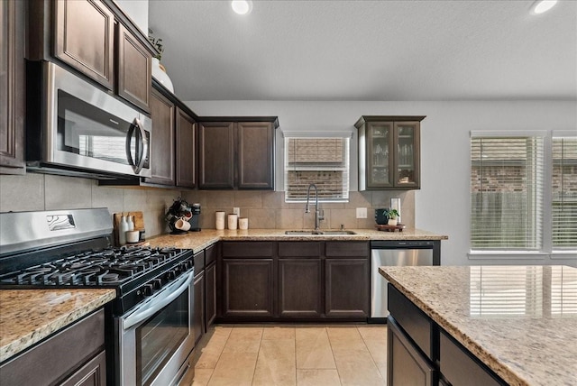 726 Rim Water Dr, Alvin, TX 77511 - kitchen featuring appliances with stainless steel finishes, a sink, dark brown cabinets, tasteful backsplash, and recessed lighting
