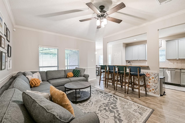 3602 Pine Stream Dr, Pearland, TX 77581 - living room featuring plenty of natural light, a ceiling fan, light wood-style floors, ornamental molding, and baseboards