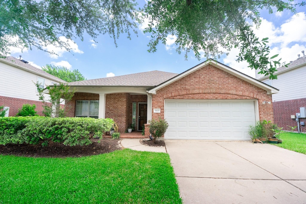 2627 Brown Pelican Ln, League City, TX 77573 - single story home featuring concrete driveway, brick siding, a garage, and a front lawn