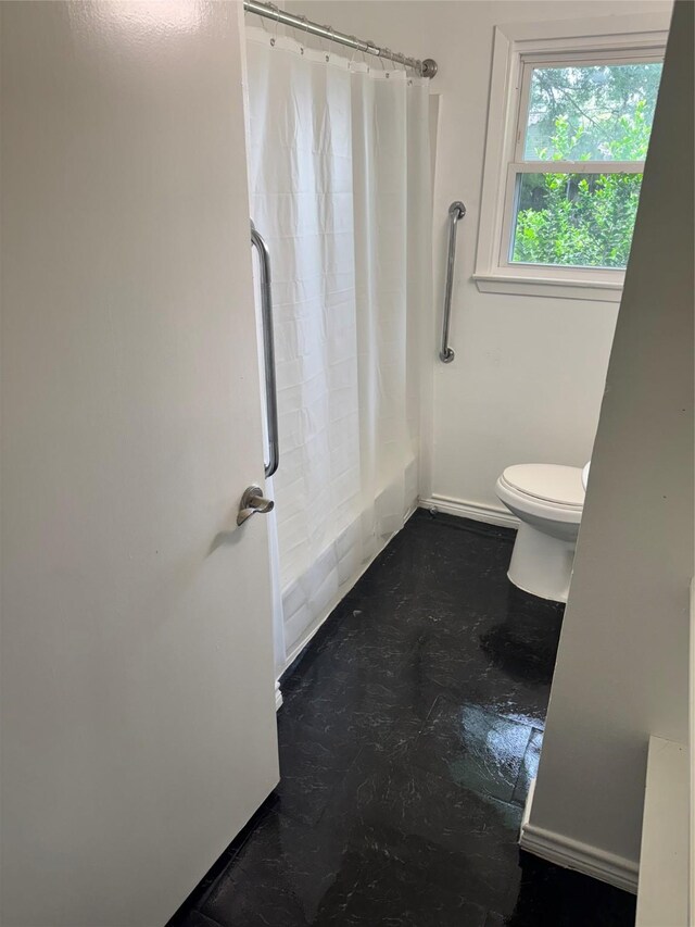 5045 Raleigh Dr, Beaumont, TX 77706 - bathroom featuring toilet, baseboards, and shower / bath combo