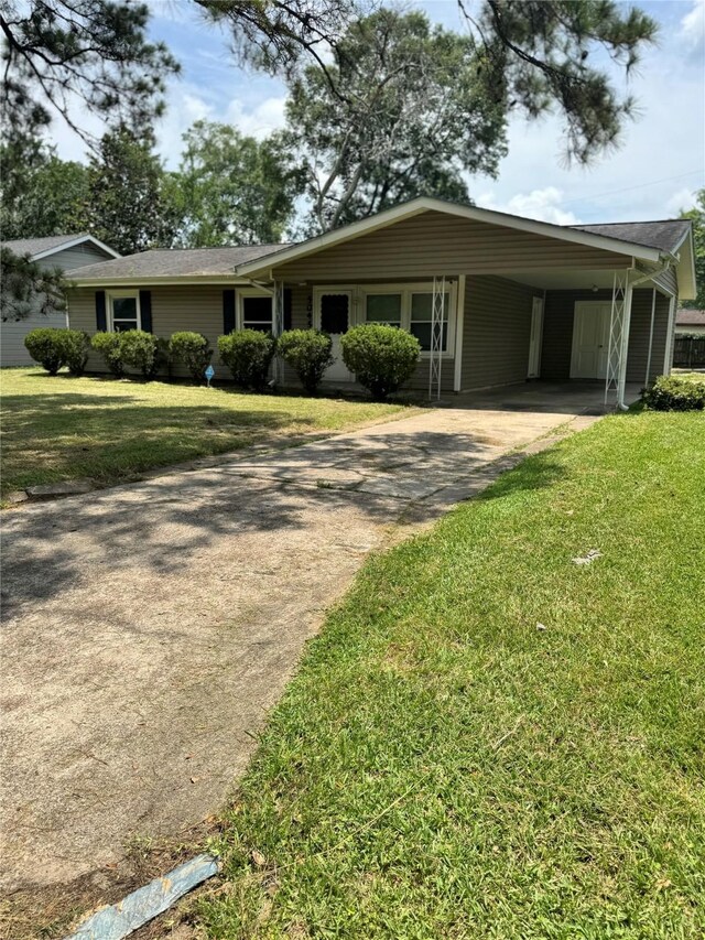 5045 Raleigh Dr, Beaumont, TX 77706 - ranch-style house featuring driveway, a front yard, and an attached carport