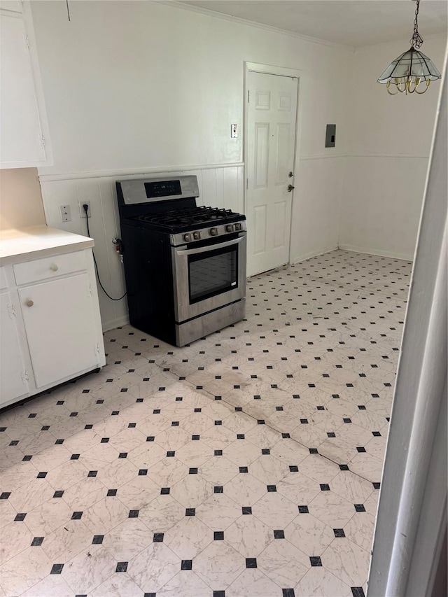 5045 Raleigh Dr, Beaumont, TX 77706 - kitchen featuring stainless steel range with gas cooktop, white cabinetry, light countertops, a wainscoted wall, and crown molding