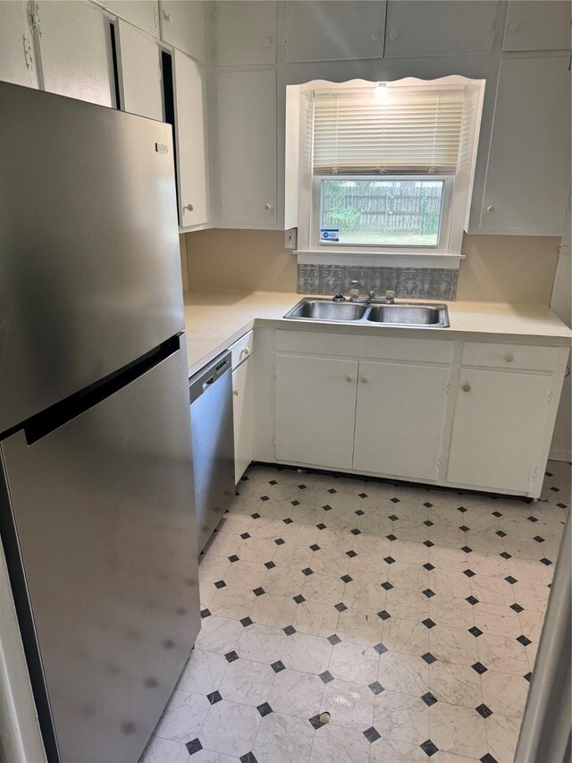 5045 Raleigh Dr, Beaumont, TX 77706 - kitchen featuring stainless steel appliances, a sink, light floors, light countertops, and white cabinetry