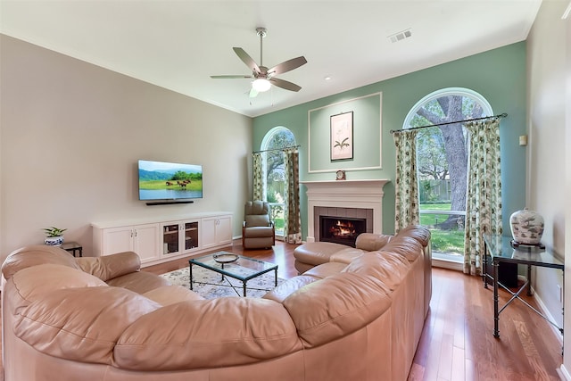 7711 Silent Star Ct, Houston, TX 77095 - living area with a ceiling fan, wood finished floors, a tiled fireplace, and baseboards
