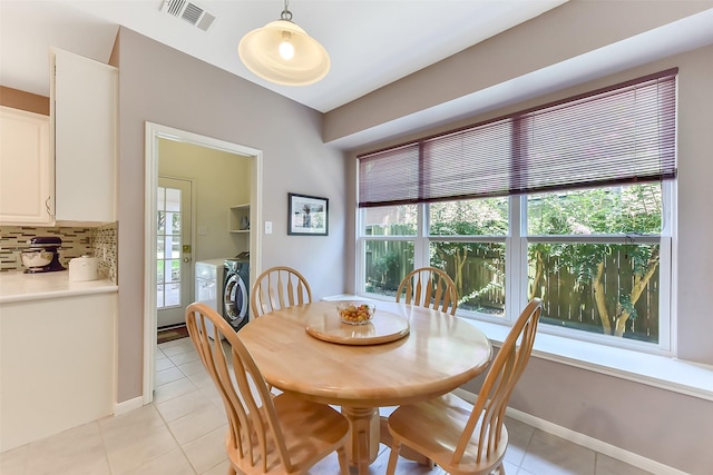 7711 Silent Star Ct, Houston, TX 77095 - dining room with washer and dryer, light tile patterned floors, healthy amount of natural light, and baseboards