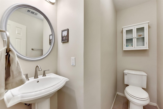 7711 Silent Star Ct, Houston, TX 77095 - half bath with a sink, toilet, tile patterned floors, and baseboards