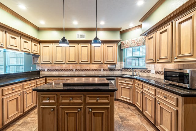 13219 Allysum Ct, Cypress, TX 77429 - kitchen featuring stainless steel microwave, a sink, crown molding, backsplash, and hanging light fixtures