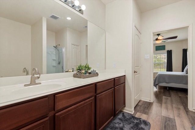 22435 Base Light Dr, Hockley, TX 77447 - full bath with wood finished floors, double vanity, an enclosed shower, ensuite bath, and ceiling fan