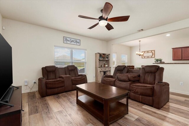 22435 Base Light Dr, Hockley, TX 77447 - living area featuring a chandelier, light wood finished floors, ceiling fan, and plenty of natural light