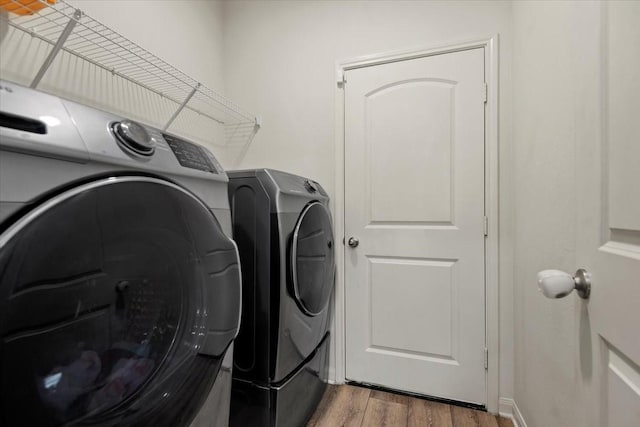 22435 Base Light Dr, Hockley, TX 77447 - washroom with washing machine and clothes dryer and wood finished floors