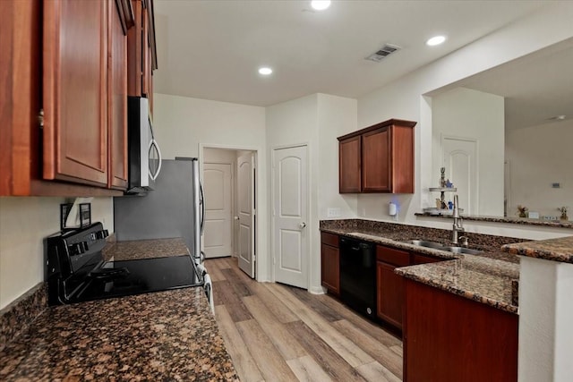 22435 Base Light Dr, Hockley, TX 77447 - kitchen featuring black dishwasher, range with electric stovetop, stainless steel microwave, light wood-style flooring, and dark stone counters