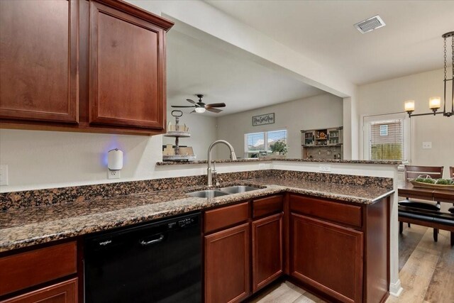 22435 Base Light Dr, Hockley, TX 77447 - kitchen with dishwasher, a ceiling fan, dark stone counters, light wood-style flooring, and a peninsula