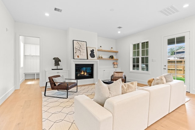 937 Louise St, Houston, TX 77009 - living area featuring light wood-type flooring, a glass covered fireplace, recessed lighting, and baseboards