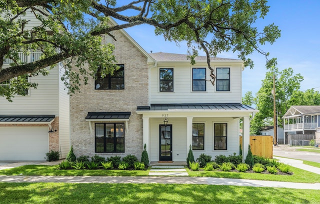 937 Louise St, Houston, TX 77009 - view of front of property featuring a standing seam roof, covered porch, brick siding, metal roof, and an attached garage