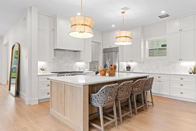 937 Louise St, Houston, TX 77009 - kitchen featuring high end refrigerator, light wood finished floors, a kitchen island with sink, decorative backsplash, and recessed lighting