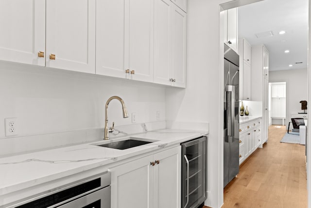 937 Louise St, Houston, TX 77009 - kitchen featuring wine cooler, a sink, white cabinets, stainless steel fridge, and recessed lighting