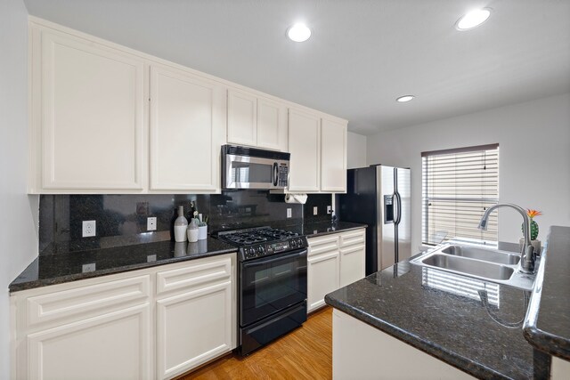 1918 Prospect St, Houston, TX 77004 - kitchen with appliances with stainless steel finishes, backsplash, white cabinets, recessed lighting, and light wood-style floors