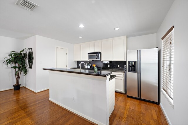 1918 Prospect St, Houston, TX 77004 - kitchen with appliances with stainless steel finishes, white cabinetry, decorative backsplash, recessed lighting, and dark wood-type flooring