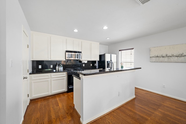 1918 Prospect St, Houston, TX 77004 - kitchen with black gas range, stainless steel microwave, fridge with ice dispenser, dark wood-style floors, and recessed lighting