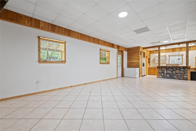 13236 Fm 1409 Unit A, Dayton, TX 77535 - unfurnished living room with wooden walls, a paneled ceiling, and baseboards