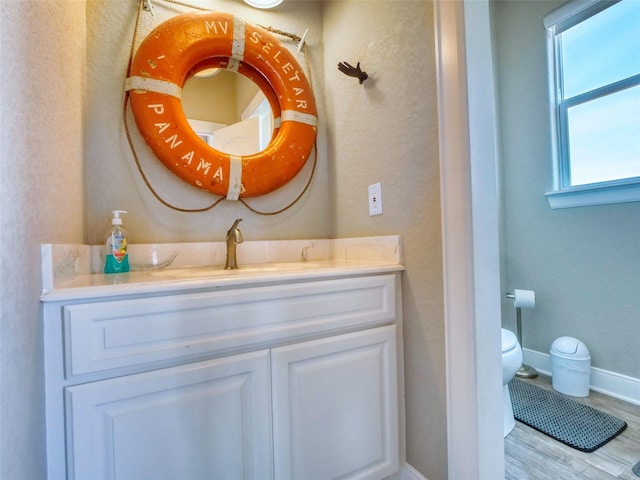 107 Yucca Ave, Surfside Beach, TX 77541 - bathroom featuring toilet, vanity, wood finished floors, baseboards, and a textured wall