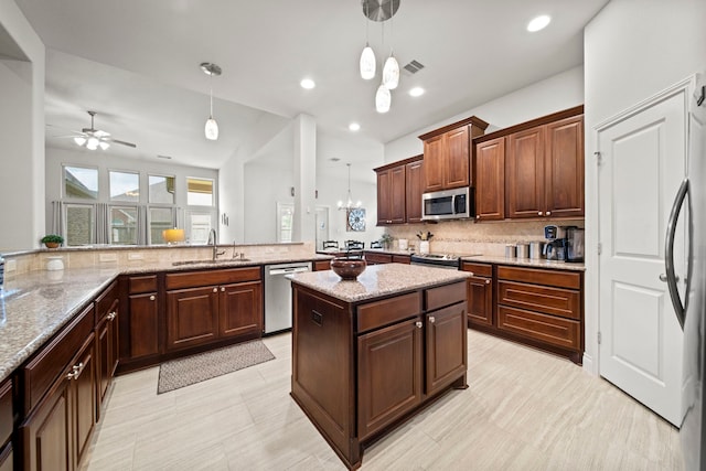 3307 Blueberry Turn Trl, Richmond, TX 77406 - kitchen featuring appliances with stainless steel finishes, a sink, tasteful backsplash, a ceiling fan, and pendant lighting