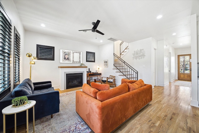 4731 Park Dr, Houston, TX 77023 - living room with ceiling fan, a fireplace, stairway, wood finished floors, and recessed lighting